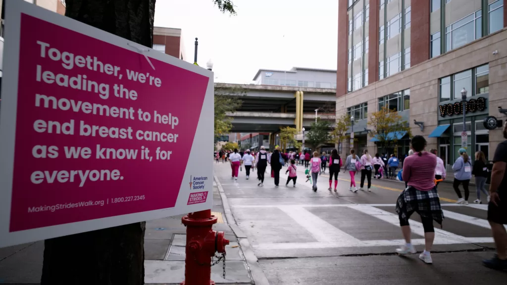 People walking next a sign in the pittsburgh Making Strides walk